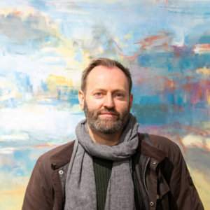 Alex Duncan standing in front of one of his paintings