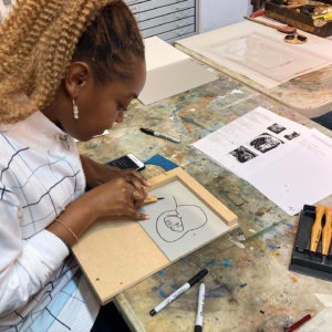 Student, Monette, linocutting on our first course in November, 2021