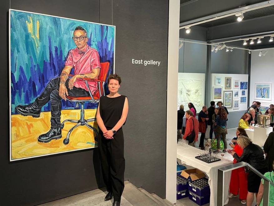 Sarah Jane Moon with her painting Lola of photographer Lola Flash, at Mall Galleries 2023 Annual Exhibition.